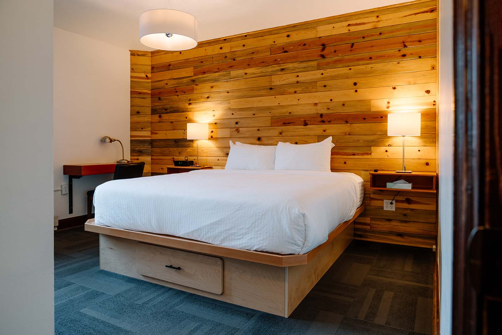 King room bed with natural wall paneling