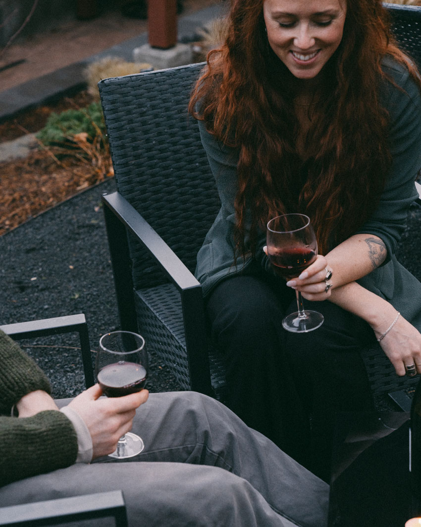 Red headed woman drinking a glass of wine