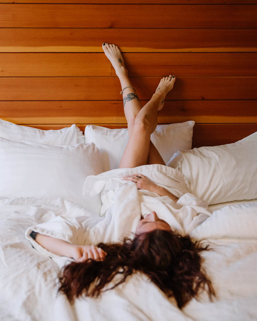 Woman lying in hotel bed in a cozy robe