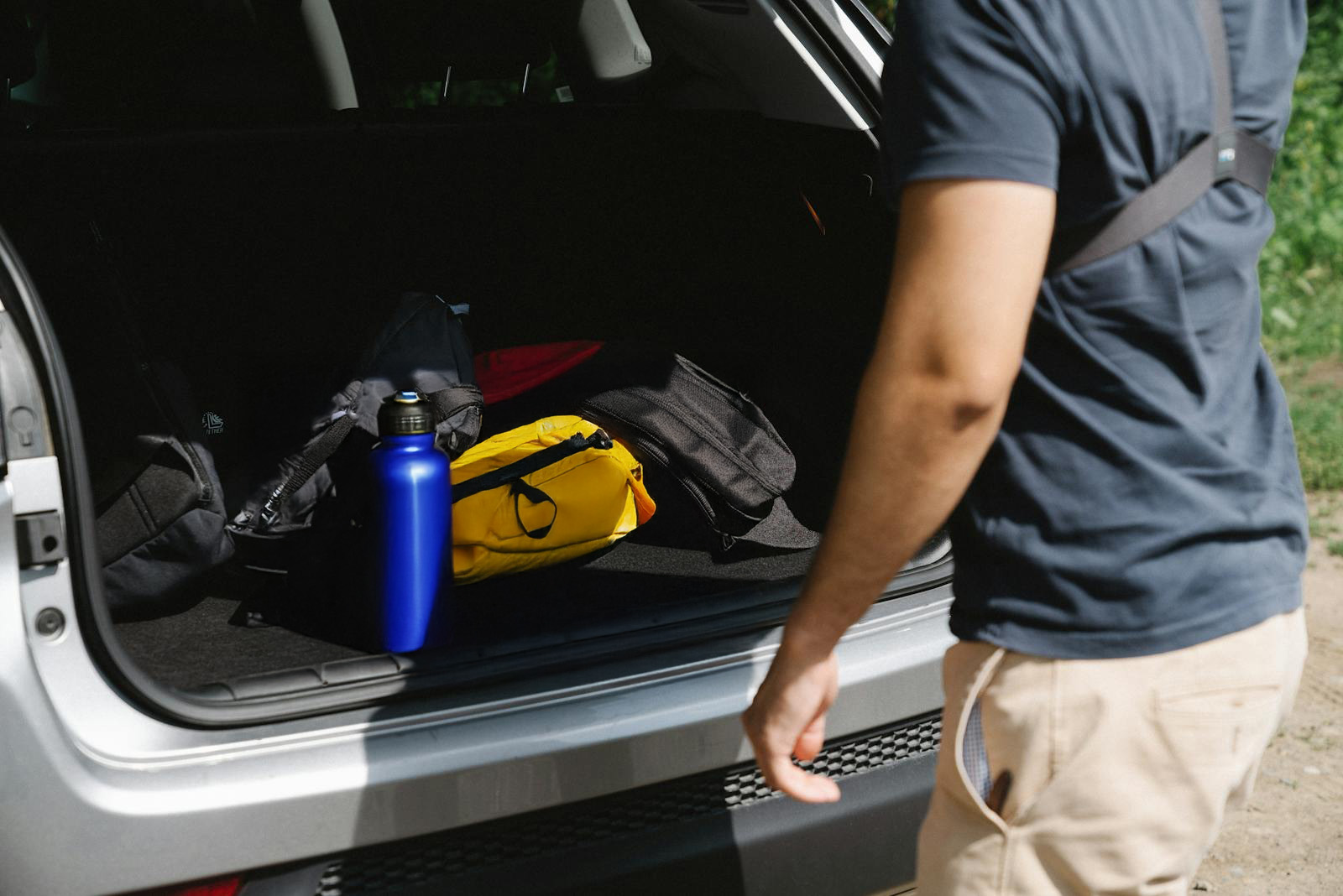 car-trunk-with-rafting-gear Man approaching car with rafting gear